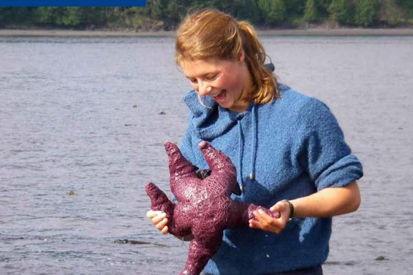 Marine and Coastal Science Program Guide showing red haired student examining a purple starfish.