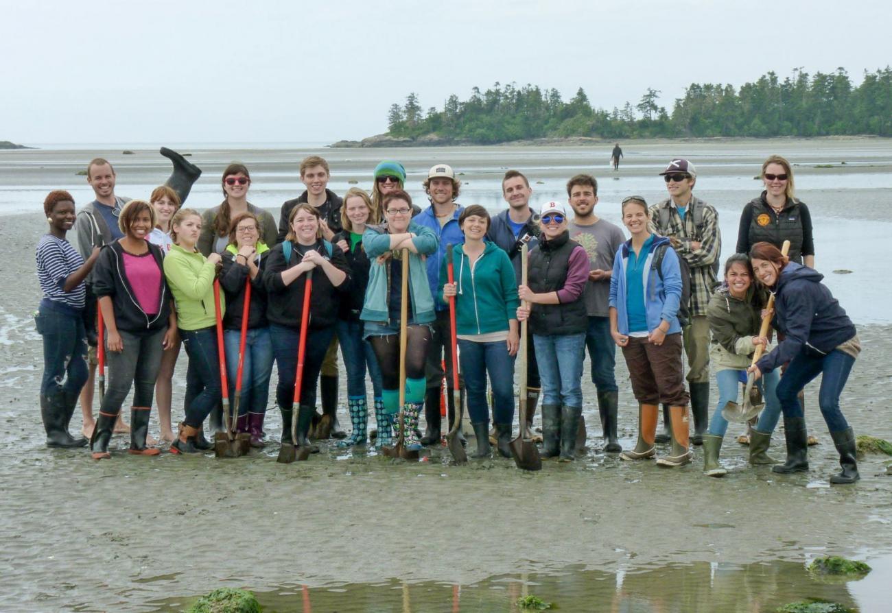 Students on a beach with shovels